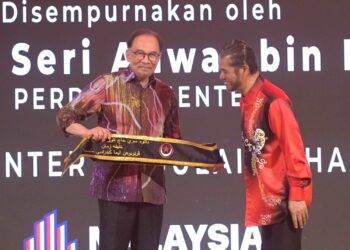 ANWAR Ibrahim menerima selempang pada perasmian penubuhan Pertubuhan Lima Generasi (PLG) Malaysia di Ipoh hari ini. - UTUSAN/ZULFACHRI ZULKIFLI.