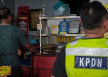 PENGUAT kuasa KPDN Melaka memeriksa sebuah premis yang dilaporkan mengenakan caj transaksi kod QR. - UTUSAN/SYAFEEQ AHMAD