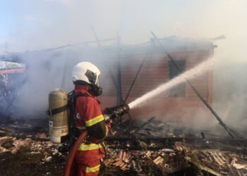 ANGGOTA bomba memadamkan api yang memusnahkan sebuah  rumah sewa  di Kampung Pontian Besar, Pontian.