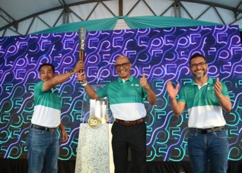 KETUA Pegawai Eksekutif Petronas Chemicals MTBE, Fauzamsaari Geran (kiri) menyerahkan replika obor kepada Norazlan Subaha (tengah) sempena sambutan 50 tahun Petronas, sambil diperhatikan oleh M. Ahmad Shazly Ramli (kanan), di stesen Petronas KotaSAS di Kuantan, Pahang. - UTUSAN/SHAIKH AHMAD RAZIF
