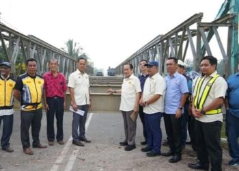 AHMAD MASLAN (empat dari kanan) menunjukkan jambatan Bailey yang siap dipasang di Kampung Permatang Sepam Darat, Pontian.