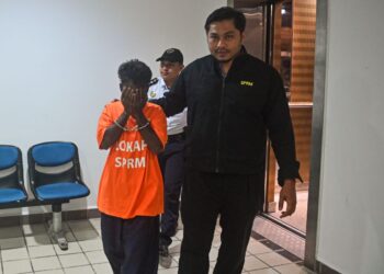 LELAKI warga Myanmar (kiri) yang ditahan reman setelah memberi rasuah seorang anggota polis dibawa keluar dari Mahkamah Majistret Kuala Terengganu, hari ini. - UTUSAN/PUQTRA HAIRRY ROSLI