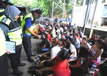 MOHD. RUSDI Mohd. Darus (dua dari kiri) menyoal pekerja asing yang ditahan dalam Op Mega Pengarah di sebuah pasar raya di Senai, Kulai.