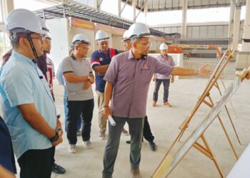 AKMAL NASRULLAH Mohd. Nasir (kiri) meninjau projek pembinaan Pasar Kampung Melayu Majidee, Johor Bahru.