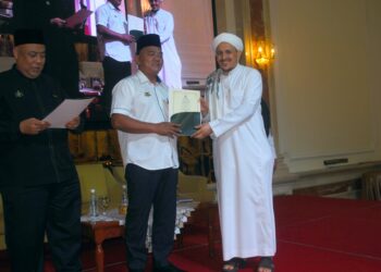 RAHMAD Mariman menyampaikan sijil pentauliahan kepada seorang penceramah selepas Majlis Penutupan Program Wacana Hadis Sempena Maal Hijrah Peringkat Negeri di sebuah hotel di Jalan Hang Tuah, Melaka. - UTUSAN/AMRAN MULUP