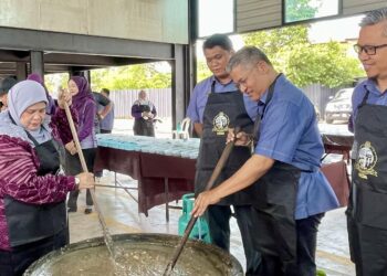 RUBIAH Wang (kiri) meluangkan masa mengacau bubur asyura pada Majlis Perhimpunan KEDA di Kompleks KEDA, Alor Setar.