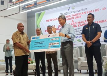 MOHAMAD Hasan menyampaikan sumbangan kepada Pengerusi Ahli Jemaah Pengarah (AJP)Pertubuhan Peladang Kawasan Rembau, Mustafa Katan selepas merasmikan Mesyuarat Agung Tahunan Pertubuhan Peladang Kawasan Rembau Kali Ke-45 di Rembau hari ini.-UTUSAN/NOR AINNA HAMZAH.