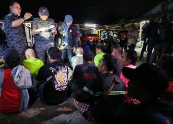 KENNITH Tan Ai Kiang memeriksa dokumen warga asing dalam serbuan di sebuah penempatan haram di Taman Bandar Senawang, Seremban awal pagi ini.-UTUSAN/NOR AINNA HAMZAH.