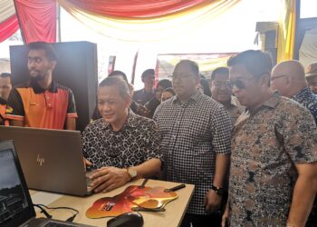 AMINUDDIN Harun mencuba penggunaan N9Pay selepas melancarkan Gerbang Pembayaran Kerajaan Negeri, Negeri Sembilan (N9Pay) di Dataran Nilai, Seremban.-UTUSAN/NUR SHARIEZA ISMAIL.