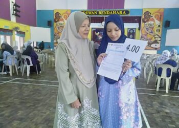 NUR Hafizah Sobri menunjukkan slip keputusan STPM kepada ibunya, Asma Harun selepas majlis pengumuman di Dewan Bendahara, SMK Yan di Yan.