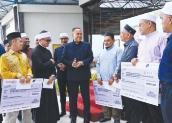 AHMAD Samsuri Mokhtar (lima, kanan) berbual mesra bersama sebahagian imam ketiga pada Majlis Penyerahan Bayaran Bantuan Khas ‘One Off’ Tahun 2023 kepada imam ketiga masjid mukim negeri Terengganu di Kuala Terengganu, semalam. – UTUSAN/KAMALIZA KAMARUDDIN