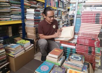 AHMAD Saifuddin Amran mempamerkan buku-buku terpakai di kedainya di Bistro Pustaka dekat Jalan Cempaka 24, Desa Cempaka, Nilai, Seremban. – UTUSAN/NUR SHARIEZA ISMAIL