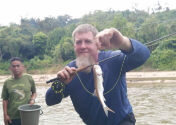 CHRISTOPHER John Mcllravy  menunjukkan ikan sikang yang berjaya ditangkap menggunakan teknik pancing layang di Sungai Berang, di Kampung Betong, Hulu Terengganu, semalam. – UTUSAN/NOOR HAYATI MAMAT