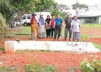 PENDUDUK Taman Atara Perdana, Indera Mahkota 2 di Kuantan, Pahang menunjukkan lokasi tapak menara telekomunikasi yang bakal dibina di kawasan padang perumahan tersebut. – UTUSAN/DIANA SURYA ABD. WAHAB