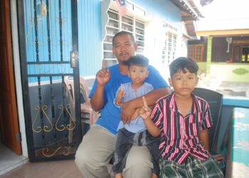 ROSLAN Jalil bersama dua anaknya, Muhammad Hasbunallah dan Muhammad Malik ketika ditemui di Kampung Lapan, Bachang, Melaka. – UTUSAN/AMRAN MULUP
