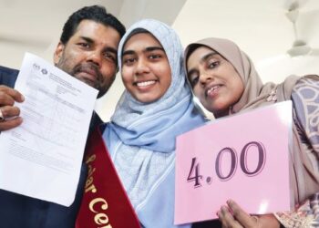 NUR Fadzlina Thaulath (tengah) diapit oleh kedua ibu bapanya, Nabisha Abdul Jaleel dan Thaulath Darmenullansadee selepas diumumkan antara pelajar cemerlang STPM 2023 di Kolej Tingkatan Enam Haji Zainul Abidin, Pulau Pinang. – UTUSAN/IQBAL HAMDAN