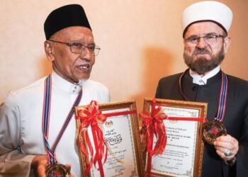 HASSAN Ahmad (kiri) dan Dr. Ali Muhyiddin Ali Al-Qaradaghi menerima trofi dan sijil penghargaan sempena Sambutan Maal Hijrah Tahun 1446H/2024M di PICC, semalam. – UTUSAN/FAISOL MUSTAFA