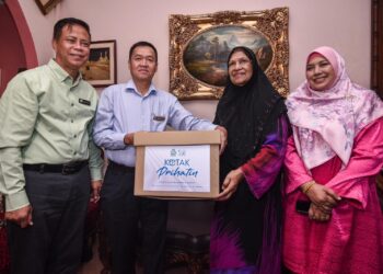 Mohamad Asri Ngosman menyampaikan Faedah Pencen Penakat kepada Noor Hamid, ibu kepada Allahyarham Kamal Huzaini Kamaludin di kediamannya di Taman Ampang Jaya, Kuala Lumpur pagi ini. -UTUSAN/M Firdaus M Johari