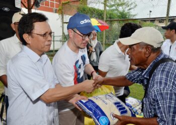 MOHD. Shafie Apdal (kiri) menyampaikan bantuan bakul makanan kepada penduduk Kampung Sembulan di Kota Kinabalu, Sabah hari ini.