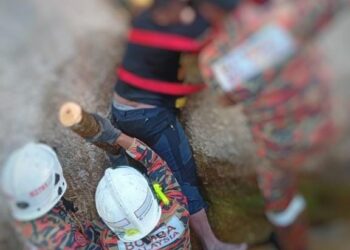 ANGGOTA Bomba dan penduduk kampung berusaha menyelamatkan mangsa yang tersepit pada bongkah batu dalam  kejadian di Kampung Kuala Balah, Jeli, Kelantan semalam.