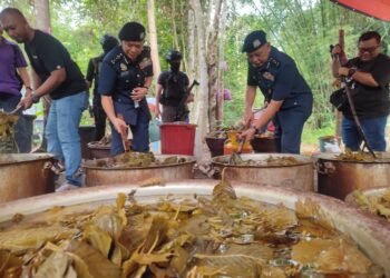 WAN Abdul Jamal Wan Long (dua kiri) memeriksa rebusan air daun ketum semasa melakukan serbuan di Machang, Kelantan hari ini.