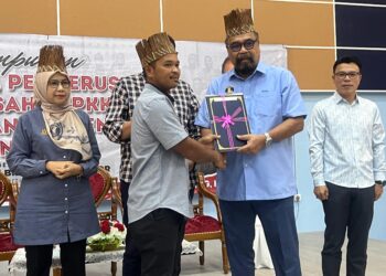 RAMLI Mohd. Nor (kanan) menyampaikan surat lantikan kepada Pengerusi JPKKOA Orang Asli di Dewan Bonda Yah, Rancangan Pengumpulan Semula (RPS) Kuala Betis di Gua Musang, Kelantan hari ini.UTUSAN/AIMUNI TUAN LAH.