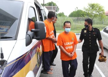 KEDUA-dua tertuduh memakai baju lokap SPRM semasa tiba untuk mendapatkan perintah tahana reman di Mahkamah Kota Bharu, Kelantan hari ini-UTUSAN/ROSLAWANI CHE SOH.