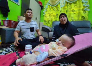 MOHAMMAD Asri Sabri dan isteri, Nurul Amiza Md. Noor tabah menjaga anak mereka, Nur Afiyah yang didiagnosis menghidap penyakit jantung berlubang selain menderita akibat penyakit sumbing bibir dan lelangit di Kampung Permatang Tok Gelam, Butterworth, Pulau Pinang.-UTUSAN/IQBAL HAMDAN