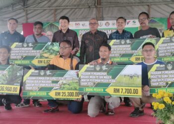 MOHD. Zolkafly Harun (belakang, empat dari kiri) bersama peserta yang menerima geran pertanian pada Hari Ladang Pejabat Pertanian Daerah Kerian di Parit Buntar hari ini. - UTUSAN/WAT KAMAL ABAS