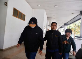 SAZALI Lokhman (kiri) dikawal pegawai SPRM ketika dia dihadapkan ke Mahkamah Sesyen Alor Setar. -UTUSAN/SHAHIR NOORDIN