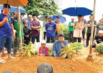 ABD. Halid Sugiman (duduk) membaca talkin tanda penghormatan terakhir untuk Hafiz Fauzan yang disemadikan di Tanah Perkuburan Islam Batu 7, Tongkang Pechah, Batu Pahat, Johor, semalam.
