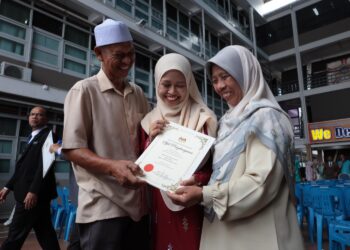 AMNI Zafirah Shahril menunjukkan sijil penghargaan JPN Perak atas kecemerlangannya memperoleh PNGK 4.0 pada STPM 2023 kepada ibu bapanya di JPN Perak di Ipoh hari  ini. - UTUSAN
