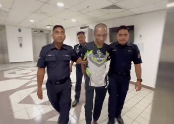 MOHD. Fadzri Idzuan Mustapha (tengah) yang mengaku salah memukul ibu kandung sehingga cedera  dibawa keluar dari Mahkamah Sesyen Kuala Terengganu, hari ini. - UTUSAN/PUQTRA HAIRRY ROSLI