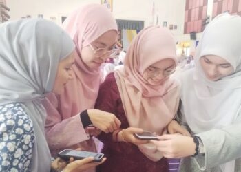 EMPAT pelajar melihat keputusan STPM melalui telefon pintar di SMK Nasiruddin, Besut, semalam. – UTUSAN/WAN ZURATIKAH IFFAH WAN ZULKIFLI
