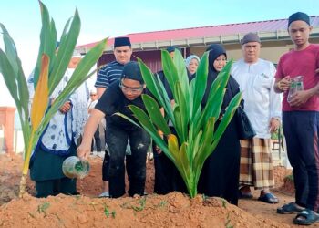 AHLI keluarga Muhamad Firdaus Abdull Fatah menjirus air mawar selepas pengebumian di Tanah Perkuburan Islam Parit Jaya,  Matang Jelutong, Bagan Serai, Perak, hari ini. - UTUSAN/WAT KAMAL ABAS
