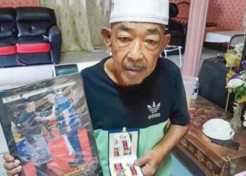 MOHD. HILMAN Selamat menunjukkan Pingat Jasa Malaysia (PJM) yang diterima di rumahnya di Kampung Tanjung Air Hitam, Pontian, Johor.