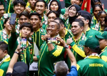 MUHAMMAD Sanusi Md. Nor berswafoto bersama atlet Kedah yang akan bertanding dalam Sukma Sarawak pada Majlis Penyerahan Bendera Kontinjen di Stadium Sultan Abdul Halim, Suka Menanti di Alor Setar. -UTUSAN/ SHAHIR NOORDIN