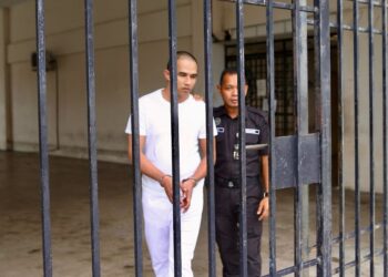 MD. Isham Desa dikawal anggota polis ketika dibawa ke Mahkamah Sesyen Alor Setar. -UTUSAN/ SHAHIR NOORDIN