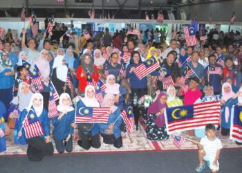 K. SARASWATHY (tengah) bersama orang ramai mengibarkan Jalur Gemilang selepas Majlis Pelancaran Malaysiaku Merdeka Peringkat Negeri Melaka 2024 di Pusat Dagangan Antarabangsa Melaka (MITC), Ayer Keroh, Melaka. – MINGGUAN/AMRAN MULUP