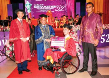 MUHAMMAD Hafizuddin Mohd. Yamin yang berkerusi roda menerima diploma disampaikan Saarani Mohamad pada Istiadat Konvokesyen Politeknik Ungku Omar (PUO) di Ipoh, Perak, semalam. – UTUSAN/MUHAMAD NAZREEN SYAH MUSTHAFA