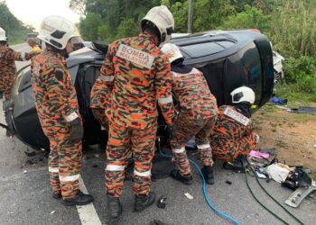 ANGGOTA bomba mengeluarkan mangsa yang tersepit dalam kemalangan di Jalan Kuala Kangsar-Manong hari ini. - UTUSAN/IHSAN JBPM