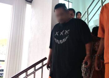 SUSPEK (baju hitam) diiringi anggota polis ketika dibawa ke Mahkamah Majistret, Alor Gajah, Melaka untuk mendapatkan permohonan reman. - UTUSAN/MUHAMMAD SHAHIZAM TAZALI