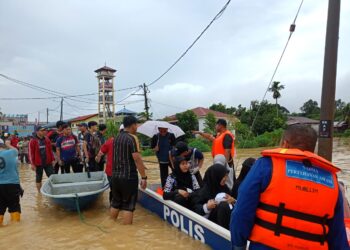 ANGGOTA APM memindahkan mangsa banjir di Tanjung Malim hari ini. - UTUSAN/FOTO APM PERAK