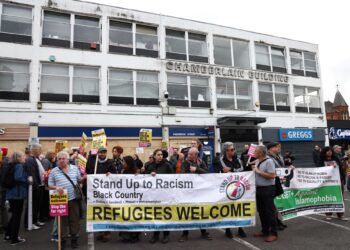 PENDUDUK memegang sepanduk 'Pelarian dialu-alukan" dalam demonstrasi membantah tindakan protes anti-pendatang dan anti-Islam oleh kumpulan berhaluan kanan di hadapan pejabat Pusat Pelarian dan Imigran di Birmingham, semalam. -AFP