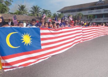 SEBAHAGIAN daripada murid dan guru bergambar bersama Jalur Gemilang gergasi yang dihasilkan sempena Hari Kebangsaan di  SK Ketengah II, Dungun, semalam. – UTUSAN/NIK NUR IZZATUL HAZWANI NIK ADNAN