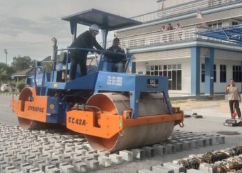 MAJISTRET Nurul Izalina Rajaai menaiki jentera penggolek untuk melupuskan barangan kes di IPD Manjung hari ini. - UTUSAN