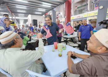 JOHARI Abdul Ghani mengagihkan Jalur Gemilang kepada orang ramai selepas pelancaran Konvoi Kembara Merdeka di Pasar Wirawati, Titiwangsa, semalam.