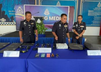 BAHRIN Mohd. Noh (tengah) menunjukkan barangan yang dirampas daripada tujuh individu yang ditahan kerana disyaki terlibat dalam kegiatan pecah sekolah dalam sidang akhbar di IPD Kluang.