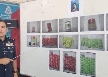 BAHRIN Mohd. Noh menunjukkan gambar dadah yang dirampas daripada seorang lelaki yang ditahan di sebuah rumah di Taman Sam Hoe, Kluang.