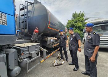 SAHARUDDIN Mohd Kia (kanan) memeriksa tangki sebuah lori yang ditahan dalam Ops Tiris 3.0 di Kawasan Perindustrian Chendering, Kuala Terengganu, hari ini. - UTUSAN/PUQTRA HAIRRY ROSLI